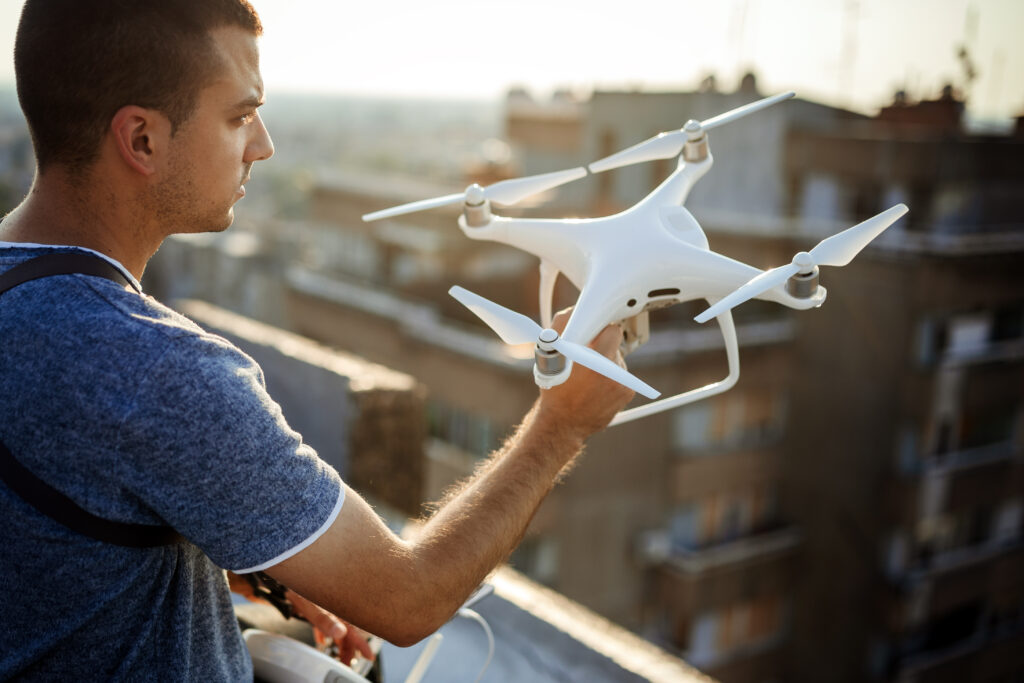 Video aéreo; hombre sosteniendo un dron en color blanco