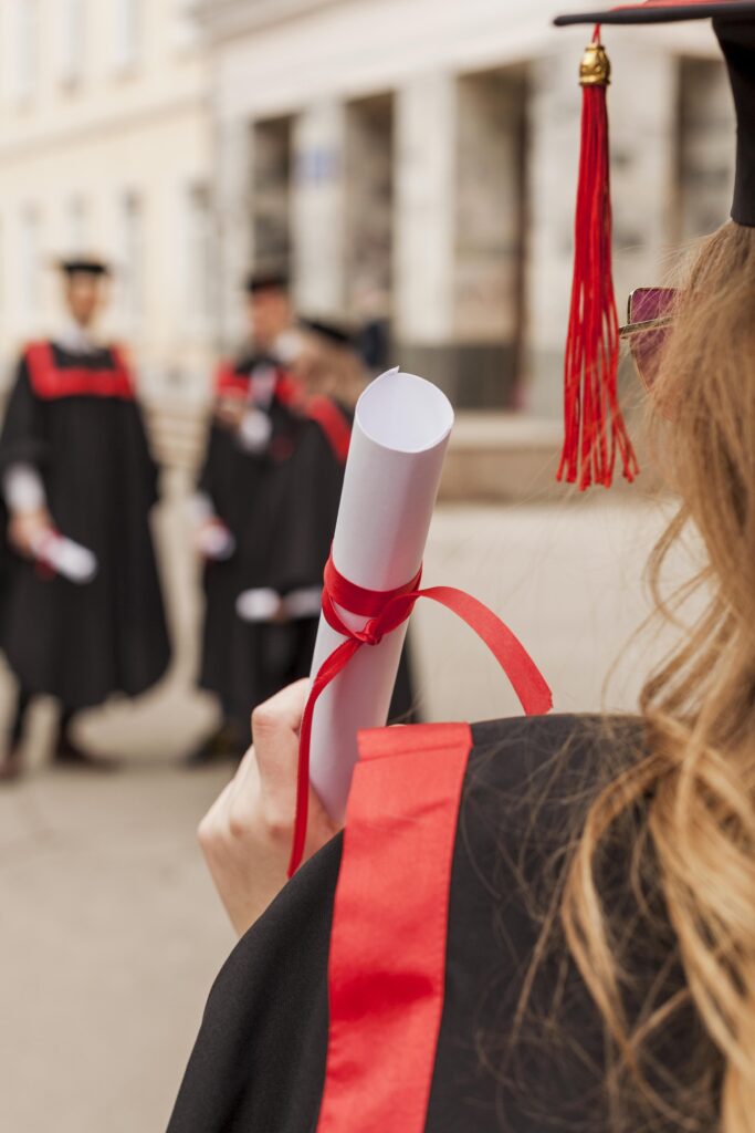 Foto de graduación; acercamiento al diploma de una chica recién graduada