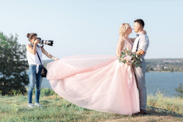 Fotógrafo de bodas; fotógrafa profesional arreglando a novios para una foto