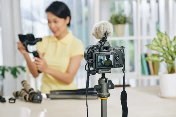 Foto de una cámara realizando el servicio de producción de video para una creadora de contenido dentro de un hogar blanco