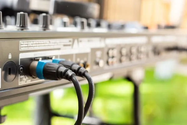 Parte posterior de una consola de audio con cables conectados, la consola forma parte de la renta de audio en Polanco