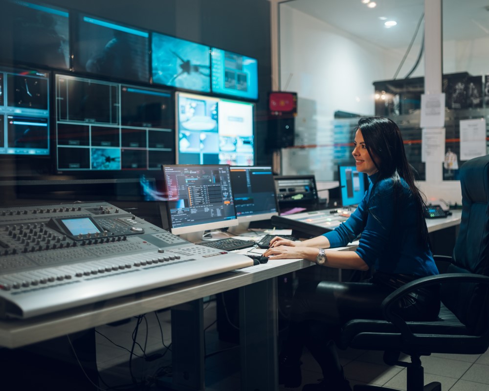 Mujer rodeada de dispositivos, reflejando la dedicación para elegir la mejor productora audiovisual para tu proyecto.