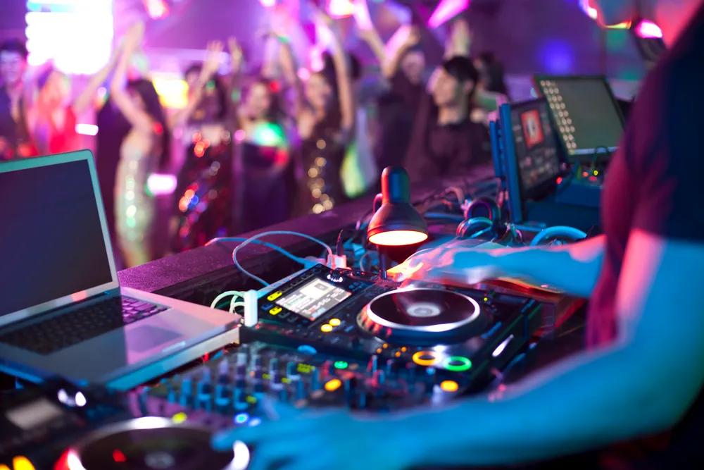 Fotografía de la consola de audio de un DJ que sabe cómo organizar un evento con el equipo de audio ideal