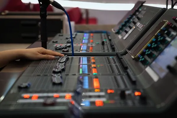 Fotografía de la mano de una persona controlando un equipo de audio profesional