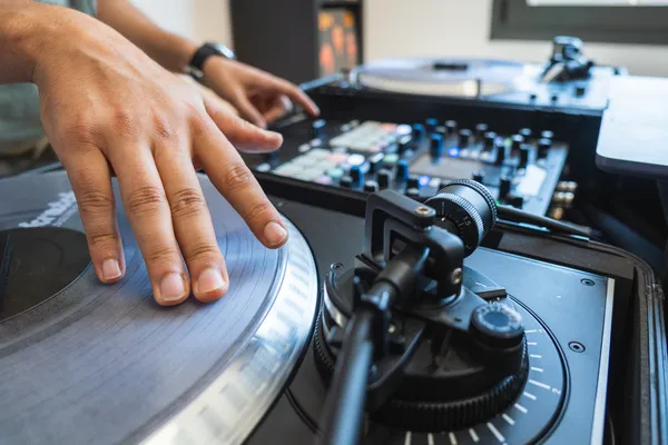 Fotografía de las manos de un Sonido DJ-Audio en vivo en un evento organizado gracias a ARLEX