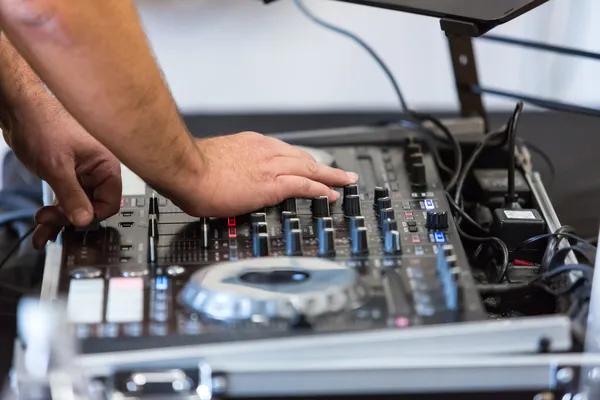 Foto de las manos de un joven operando el equipo de la renta de audio para 15 años