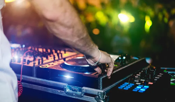 Foto de las manos de un hombre operando el equipo de la renta de audio para graduación