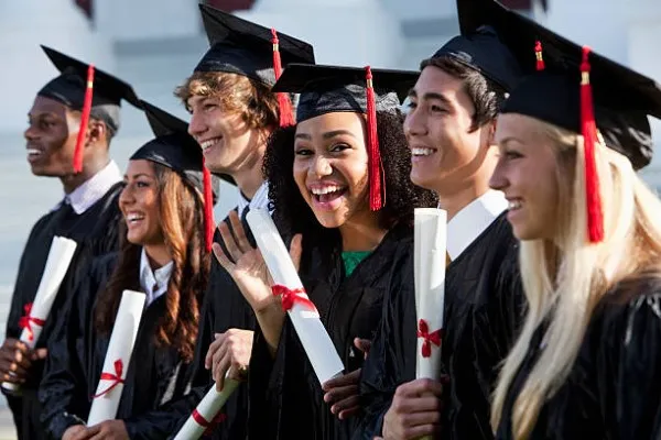 Foto de graduación de amigos universitarios con sus diplomas y togas Fotografía mientras se realiza la sesión de foto de graduación de amigos universitarios con sus diplomas y togas