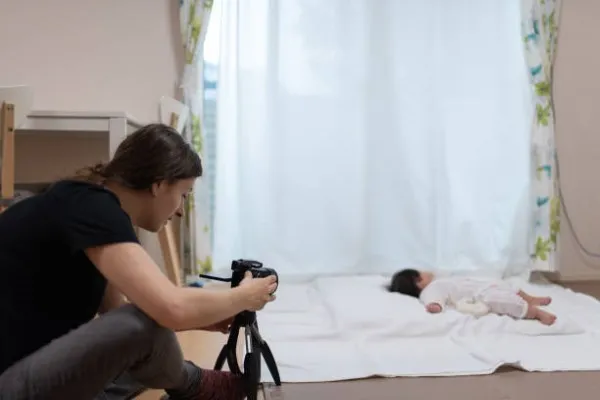 Fotografía de una joven fotógrafa realizando una sesión de fotos para bebés en su estudio decorado
