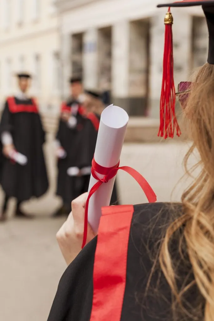 Joven universitaria con diploma yendo a su foto de graduación Fotografía de espaldas a una joven universitaria con diploma yendo a su foto de graduación con ARLEX