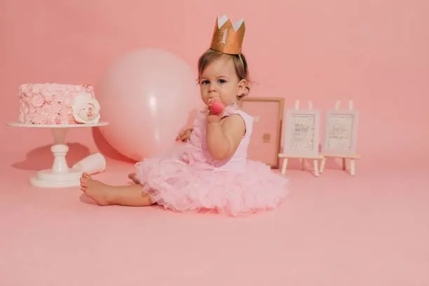 Fotografía de una pequeña niña en spot rosa de la sesión de fotos para bebés de ARLEX