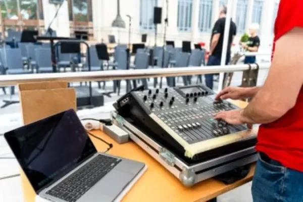 Persona manejando consola de audio computadora a un lado, parte de servicio de renta de audio en pedregal